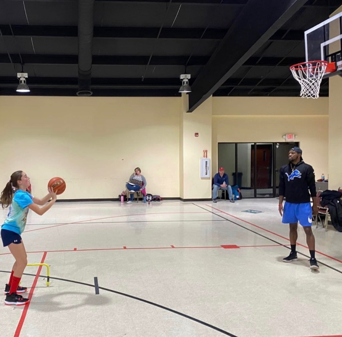 Coach Vinny watching a young athlete practice shooting