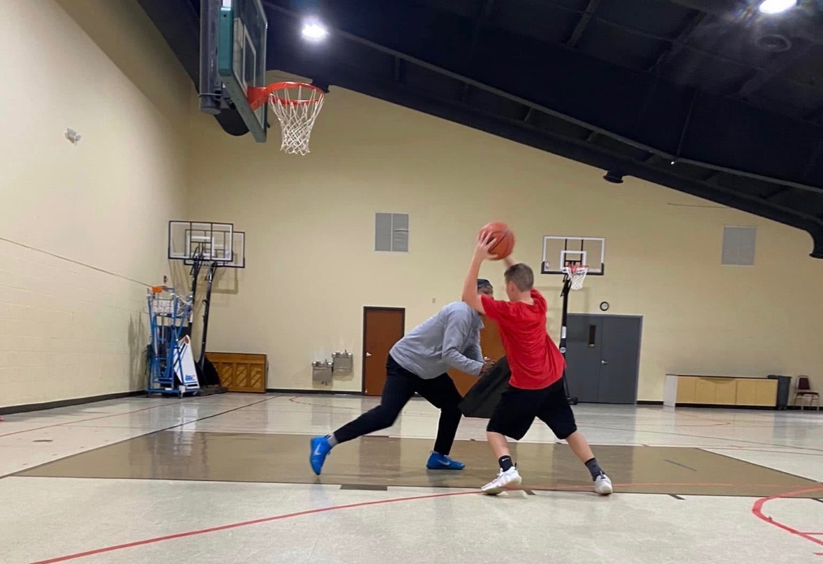 Coach Vinny working with a player during a live basketball drill